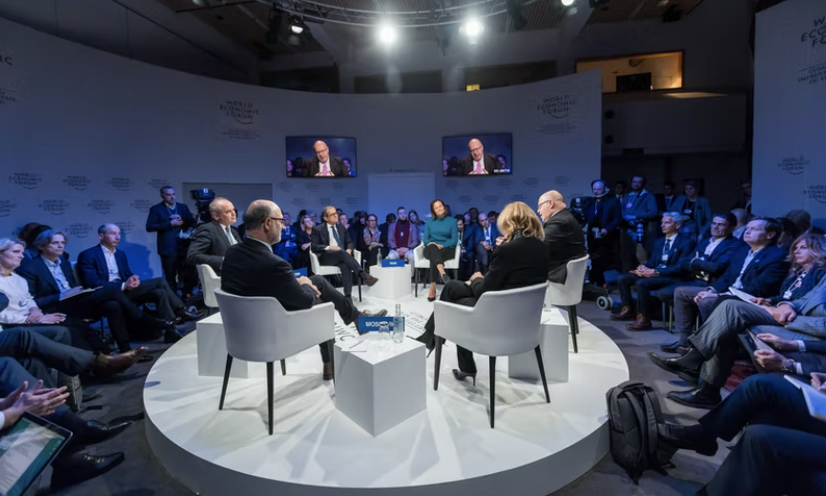 Corporate event with key speakers in the in middle under spotlight with live streaming TVS and an engaged audience surrounding them